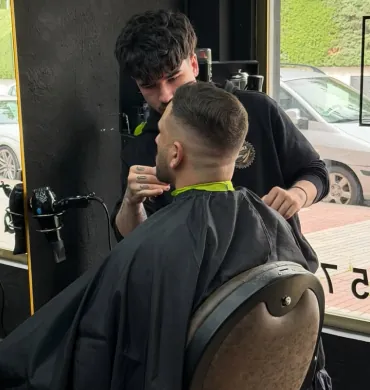 Barbero de 2 Stroke Barbershop trabajando un corte con degradado