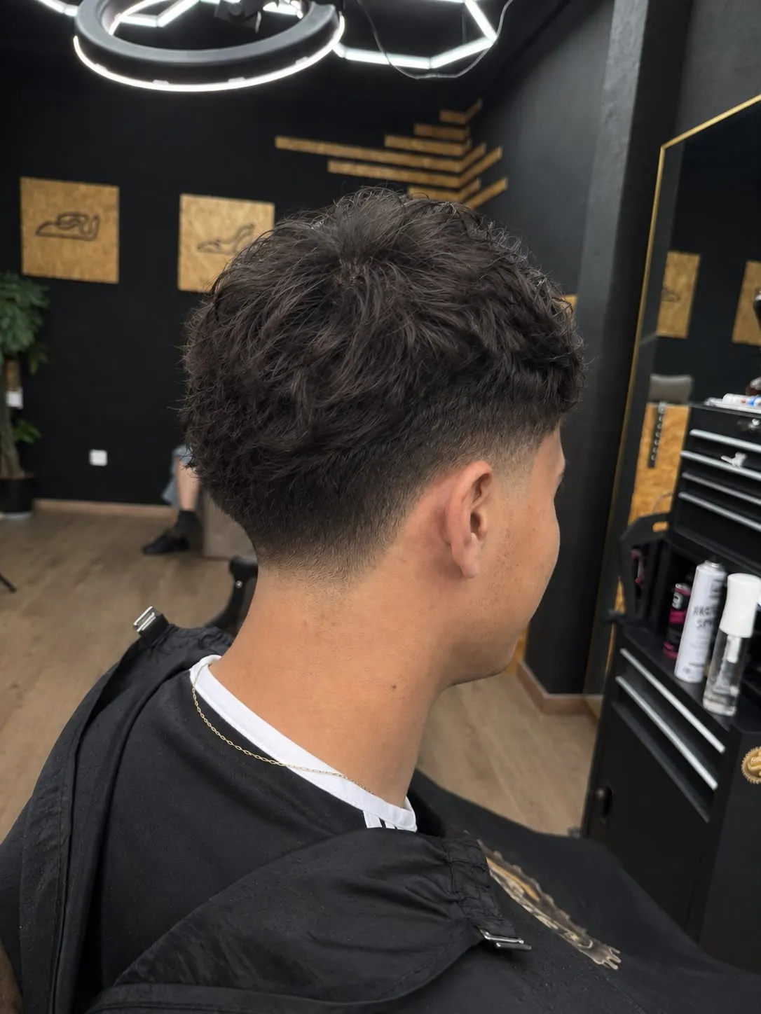 Taper fade con pelo rizado visto de espaldas en barbería de Fuenlabrada
